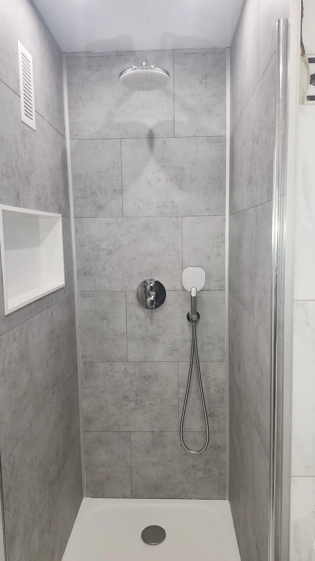 Douche italienne avec murs effet béton ciré gris et niche intégrée