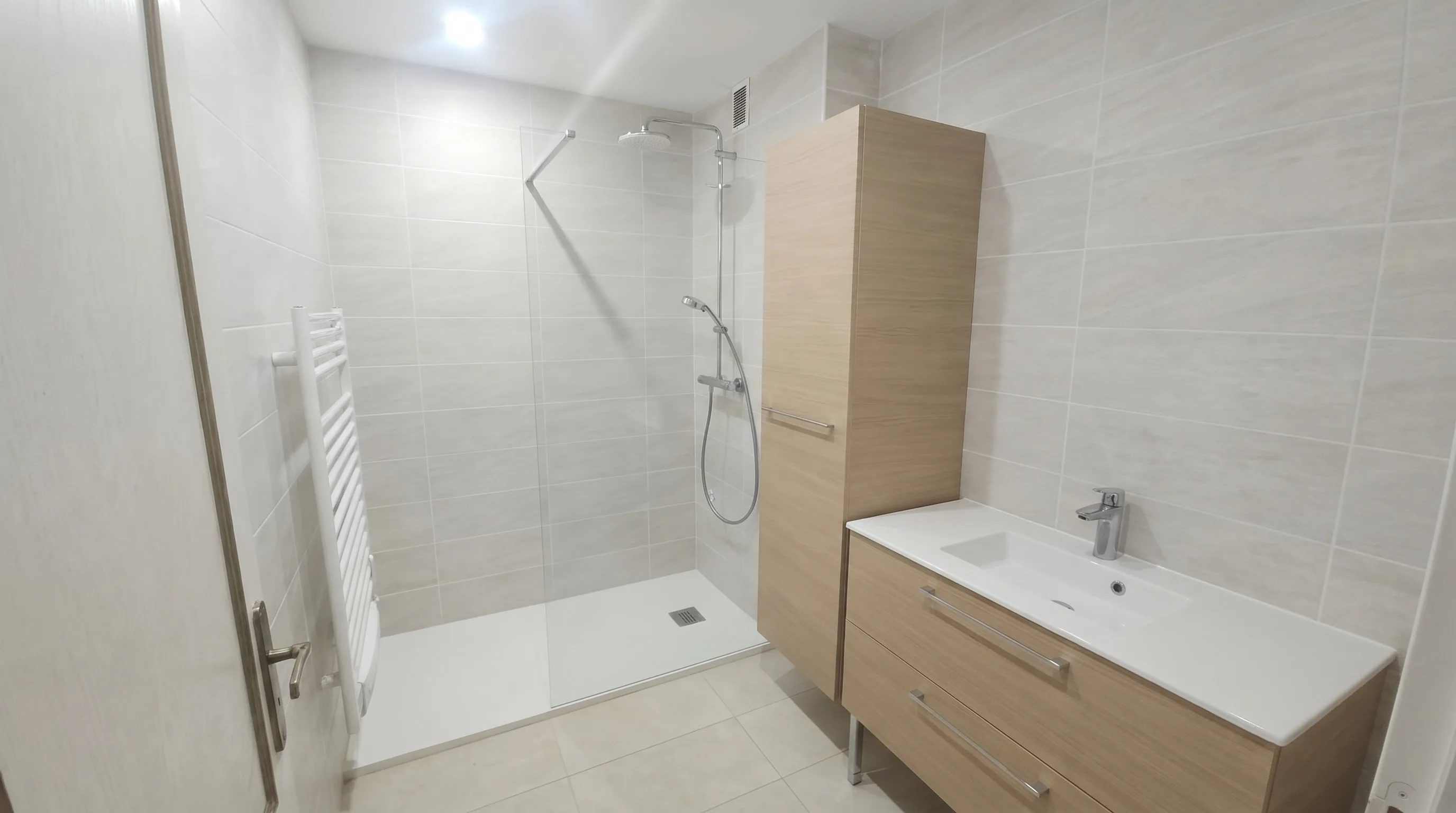 Salle de bains après rénovation : douche italienne, meuble vasque chêne, finitions soignées