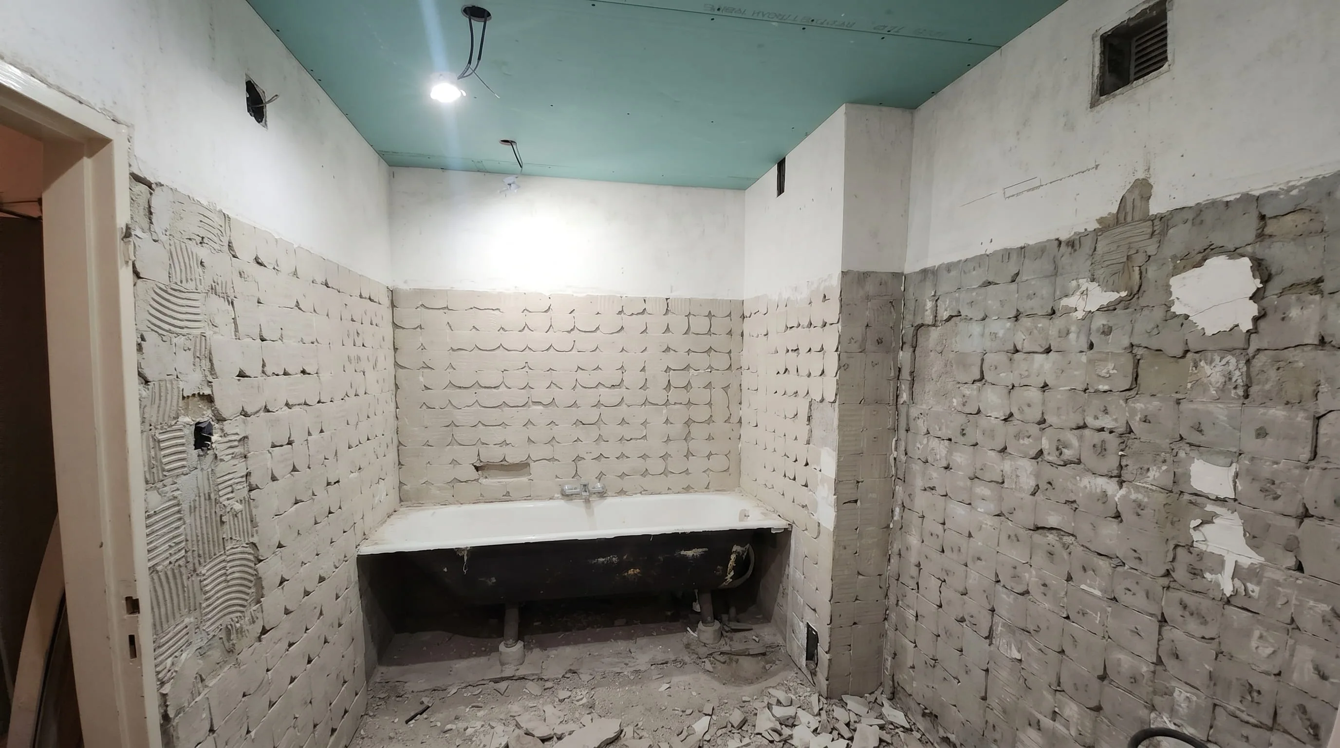 Salle de bains avant rénovation : démolition du carrelage et de la baignoire ancienne