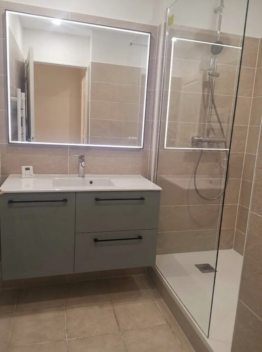 Salle de bains moderne grise avec grand miroir LED rectangulaire et douche italienne